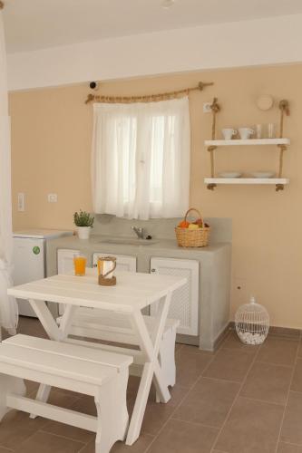 a white table and bench in a kitchen at Santa Irini 1 in Vourvoúlos