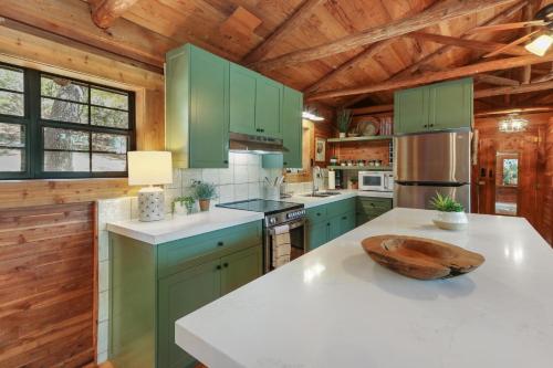 a kitchen with green cabinets and a wooden ceiling at Lajitas at The Bend in Wimberley