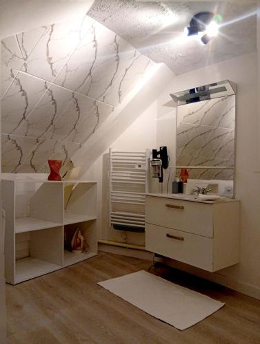 a bathroom with a sink and a mirror on the wall at L'Écrin Appart in Villedieu-les-Poêles