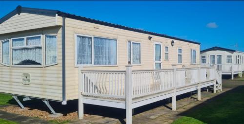 a mobile home with a porch and a deck at Skegness North Shore Holiday Park 8 Berth 3 Bedrooms in Skegness