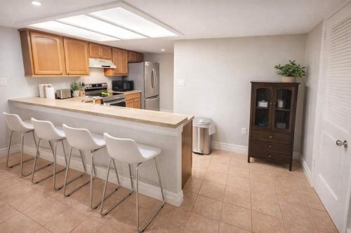 a kitchen with a bar with white stools at Saida Towers IV #108 condo in South Padre Island