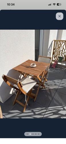 a wooden table and two chairs and a table and chairs at Le Toit des Volcans - 8 couchages - Terrasse privée et Wifi in Clermont-Ferrand