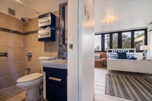 a bathroom with a toilet and a sink and a tub at Luxe Beachside Oasis Pool Parking by PH in San Juan