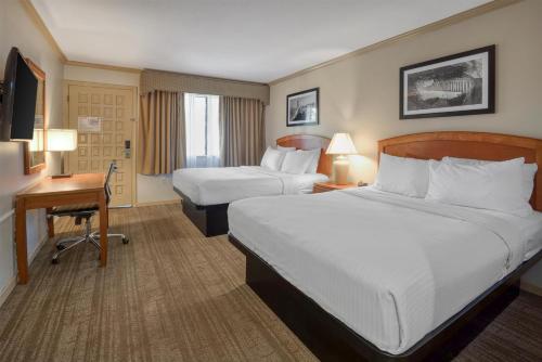 a hotel room with two beds and a desk at SureStay Plus Hotel by Best Western Mountain View in Mountain View
