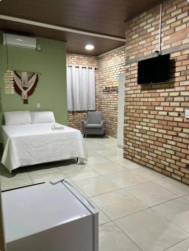a bedroom with a bed and a brick wall at Lumoa Beach Chalé Tutoia in Tutóia