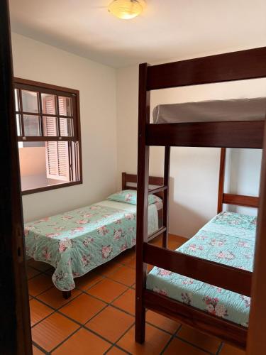 ein Schlafzimmer mit zwei Etagenbetten und einem Spiegel in der Unterkunft Prédio Jaque in Garopaba