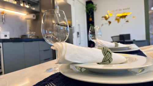 two wine glasses and a plate on a table at Ap Studio Premium luxuoso novíssimo! in Sorocaba