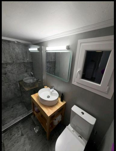 a bathroom with a toilet and a sink and a shower at Jimmy's Crib in Moúdhros