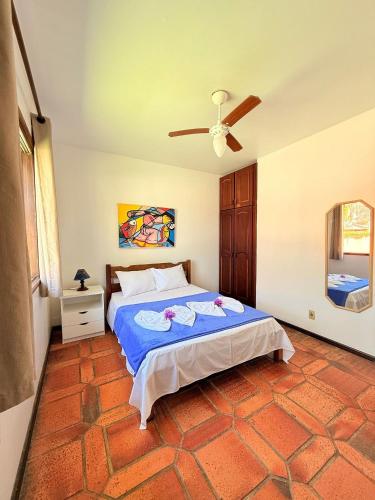 a bedroom with a bed and a ceiling fan at Residencial da Villa in Imbituba