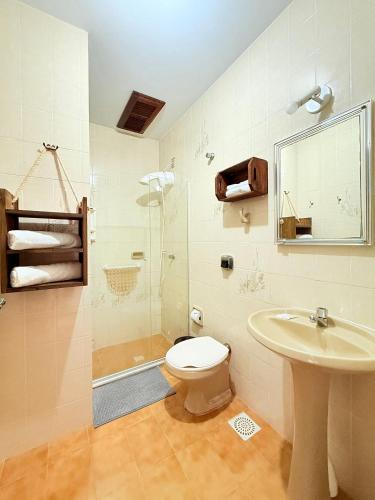 a bathroom with a toilet and a sink and a shower at Residencial da Villa in Imbituba