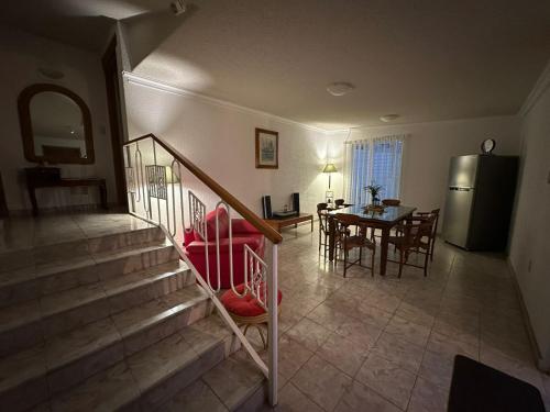 a living room with a staircase and a dining room at Casa Brasa, Sol & Jardín in Guanajuato