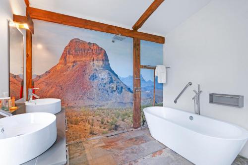 a bathroom with two sinks and a mountain mural at Ozuye Lodge in Fischer