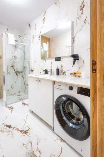 a white bathroom with a washer and dryer at NXN Airportstay in Cluj-Napoca