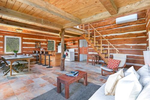 a living room with a staircase in a log cabin at Ozuye Lodge in Fischer