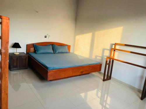 a bedroom with a bed with blue sheets and a table at Les Résidences CICA in Ouidah