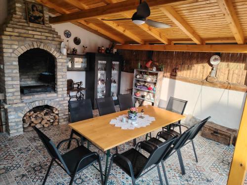 a dining room with a table and chairs and a fireplace at Apartman Katarina Bački Monoštor in Bački Monoštor