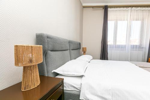 a bedroom with a bed and a table with a lamp at Residence Piata Sfatului in Braşov
