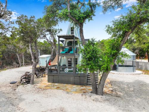 a house on the beach with a tree at Lakeview A-Frame in Canyon Lake