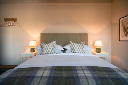 a bedroom with a large bed with two lamps at Drumornie in Brora