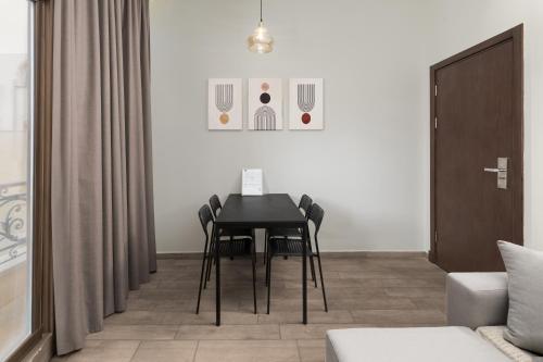 a dining room with a black table and chairs at Sleep Inn Apart-Hotel in Cairo