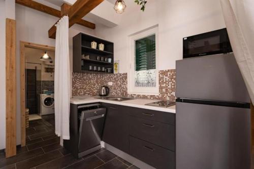a kitchen with a sink and a refrigerator at Apartment Zdravko near centar in Novalja