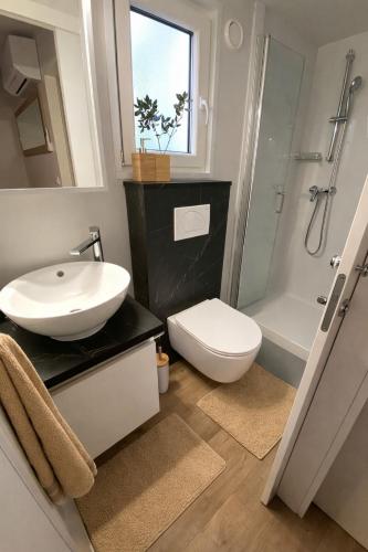 a bathroom with a sink and a toilet and a shower at Summer Stay - Mobile Home in Biograd na Moru