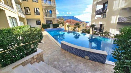 a large swimming pool in the middle of two buildings at Montenegro Royal 2 Bedroom Apartment in Bečići