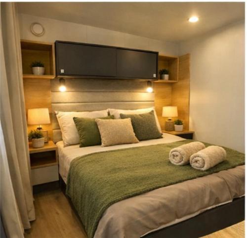 a bedroom with a large bed with two pillows at Summer Stay - Mobile Home in Biograd na Moru