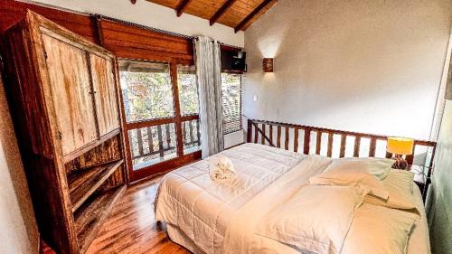 a bedroom with a bed with a cat sitting on it at Stolz Chales in Guarda do Embaú