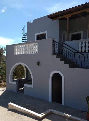 a white house with a staircase on the side at V&M Residence - Ground Level in Mesagrós