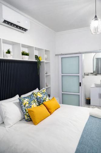 a bedroom with a white bed with yellow pillows at 27 on Donaldbain in Welkom