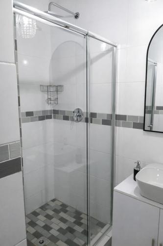 a glass shower in a bathroom with a sink at 27 on Donaldbain in Welkom