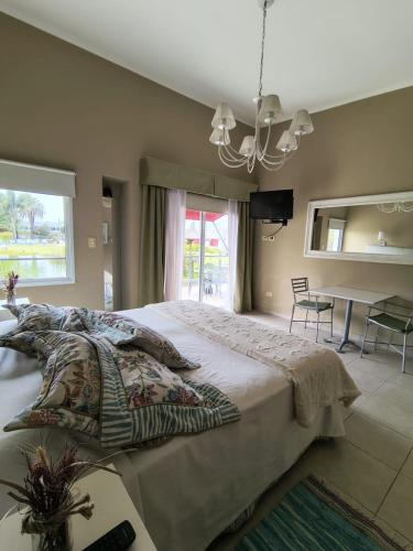 a bedroom with a large bed with a chandelier at Complejo Aquiles in Lobos