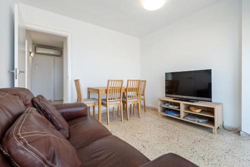 a living room with a couch and a table with chairs at Hauzify I Apartament Esmeralda in L'Ametlla de Mar