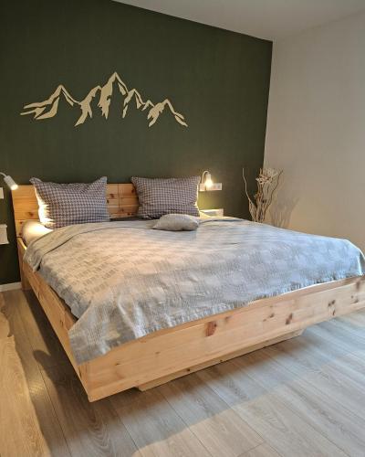 a bedroom with a wooden bed with mountains on the wall at Ferienhaus Wasserkunst in Wernigerode