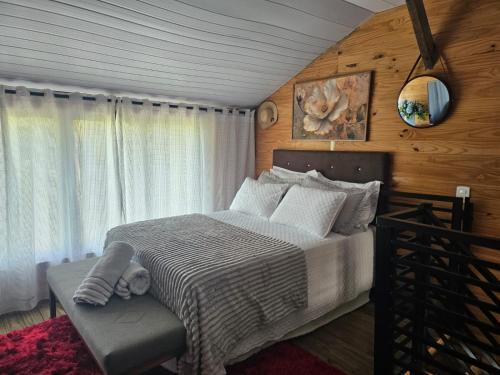 a bedroom with a bed and a chair in it at Casa Aconchegante in Pomerode
