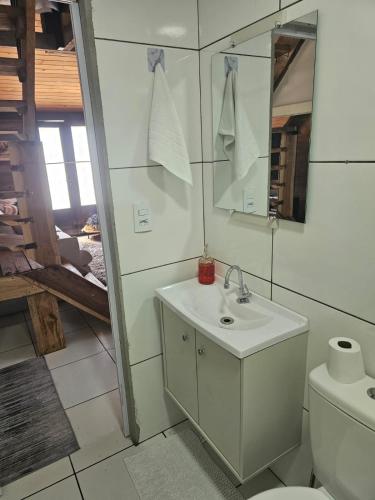 a bathroom with a sink and a toilet and a mirror at Casa Aconchegante in Pomerode