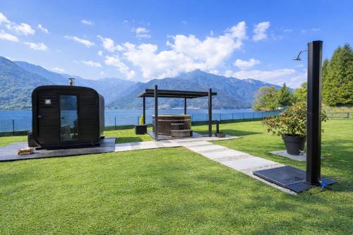 a black object sitting in the grass near the water at Villa Ledro with Private Dock - Sauna - Hot Tub in Molina di Ledro