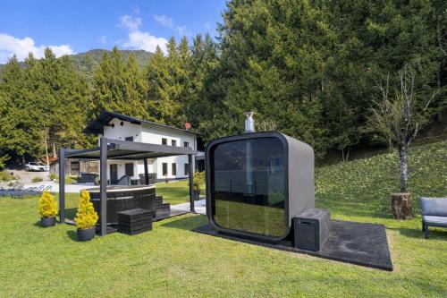 a tiny house sitting in the grass in front of a house at Villa Ledro with Private Dock - Sauna - Hot Tub in Molina di Ledro
