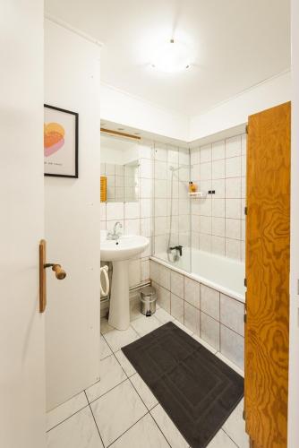 a bathroom with a sink and a tub and a toilet at Le Carnot Garden in Étampes