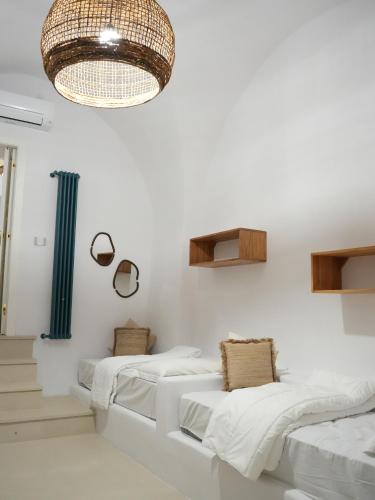 a room with three beds and a chandelier at Maison Begani66 in Gaeta