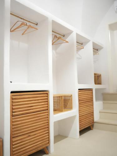 a room with white walls and wooden cabinets at Maison Begani66 in Gaeta