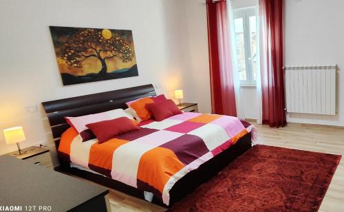 a bedroom with a bed and a painting of a tree at Joly's Home in Luco neʼ Marsi