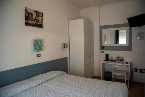 a bedroom with a bed and a table and a mirror at Albergo La Marinella in Varazze