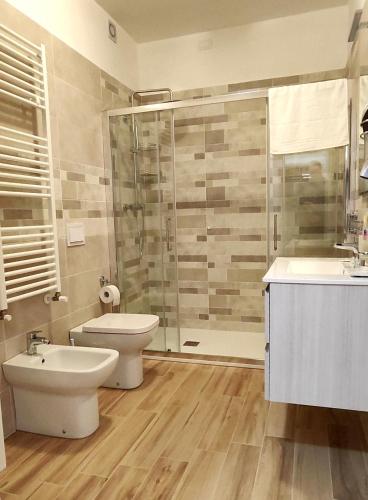 a bathroom with a shower and a toilet and a sink at Joly's Home in Luco neʼ Marsi