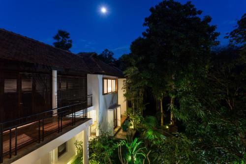 a house with a balcony at night with the moon at Sala Baï Hotel & Restaurant School in Siem Reap
