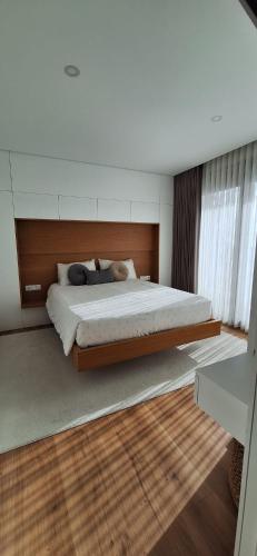 a bedroom with a large bed with a wooden headboard at PEARL by Balgrid in Viana do Castelo