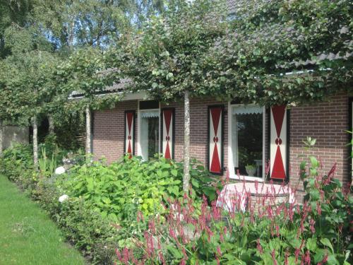 a brick house with red and white crosses on the windows at Achterhuis Hamingen in Staphorst