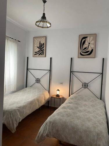 a bedroom with two beds and a lamp at Apartamento Tarramilla in Prado del Rey