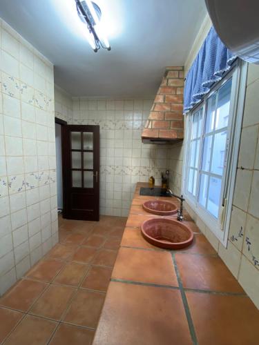 a bathroom with two sinks and a window at Apartamento Tarramilla in Prado del Rey